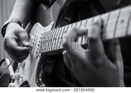 A Young Child Playing An Electric Guitar
