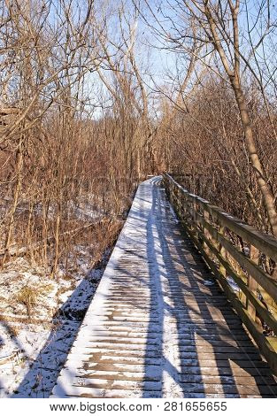 A Wooden Walkway In Frick Park, Pittsburgh, Pennsylvania, Usa Covered In Snow With The Railing Casti