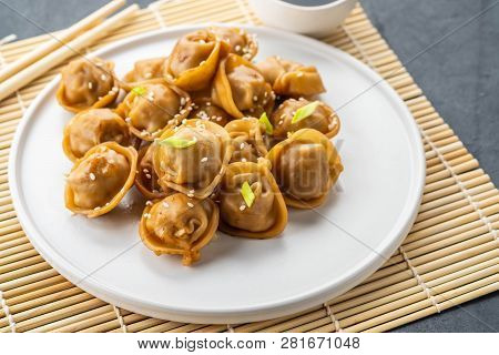 Home Made Chinese And Korean Dumplings Served On The Traditional Steamer And Bamboo Mat Decorated Wi
