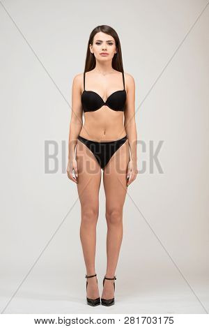 Front View Full Length Portrait Of Beautiful Brunette Women With Slim Figure In Black Bra And Shorts
