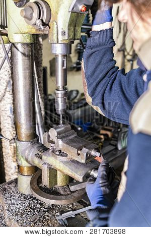 Worker Drilling With A Drillin Machine In A Factory