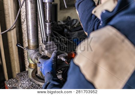 Worker Drilling With A Drillin Machine In A Factory