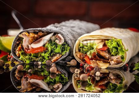 Two Burrito, Black And White Lavash With Chicken, Mushrooms, Salad, Cherry Tomatoes, Lime, And Salsa