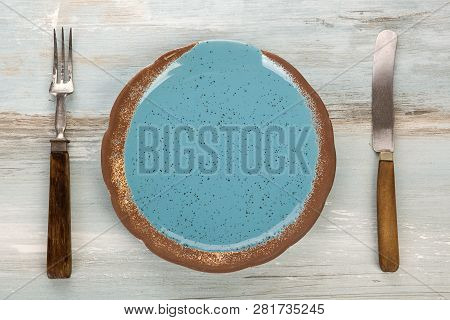 Top View Of Empty Blue Handmade Plate With Vintage Cutlery On A Grunge Background.