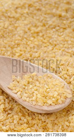 Bulgur In Wooden Spoon Close Up. Vertical With Copy Space