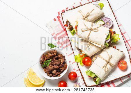 Burritos Tortilla Wraps With Beef And Vegetables On White Wooden Table.  Traditional Latin American 