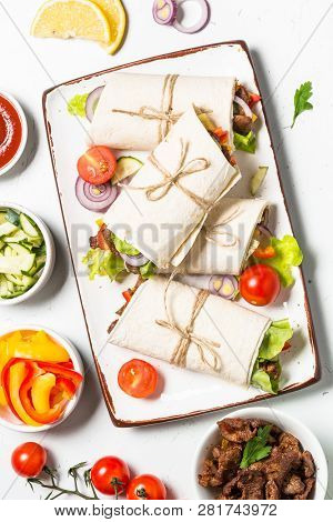 Burritos Tortilla Wraps With Beef And Vegetables On White Wooden Table.  Traditional Latin American 