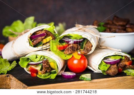 Burritos Tortilla Wraps With Beef And Vegetables On Wooden Cutting Board. Traditional Latin American