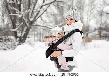 Little Baby Girl And Her Mother Walking Outside In Winter Mother Is Holding Her Baby Babywearing In 