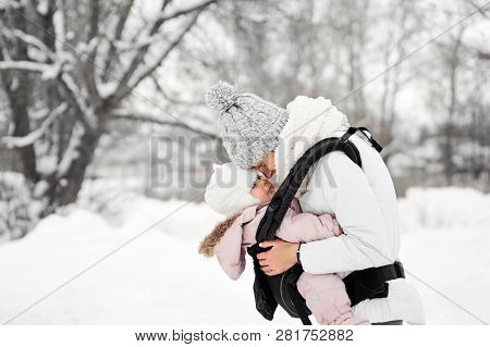 Little Baby Girl And Her Mother Walking Outside In Winter Mother Is Holding Her Baby Babywearing In 