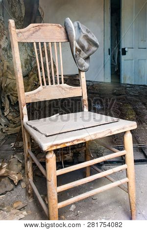 Old Abandoned Chair With A Hat Hanging Off The Post In Bodie State Historical Park In California, An