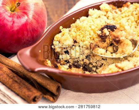 Homemade Apple Cramble Cake With Fresh Apples And Cinnamon Sticks On Rustic Dark Wooden Background