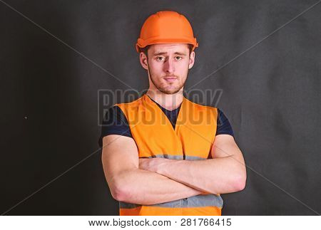Man In Helmet, Hard Hat Hold Arms Crossed On Chest, Black Background. Worker, Contractor, Builder On