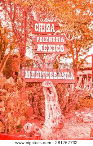 Road Sign To The Continents In The Amusement Park In Coral Color. Fashion Concept.