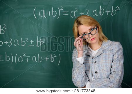 Teacher On School Lesson At Blackboard. Woman In Classroom. School. Home Schooling. Serious Woman. B