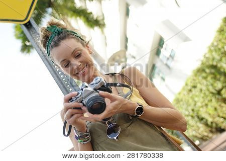 Stylish young woman with vintage camera in urban setting