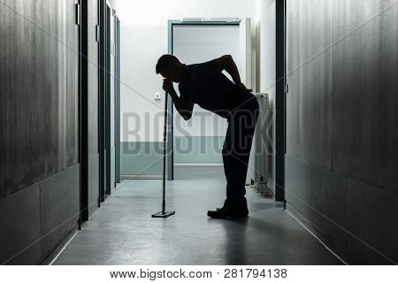 Full Length Of Man Suffering From Back Ache While Cleaning Floor