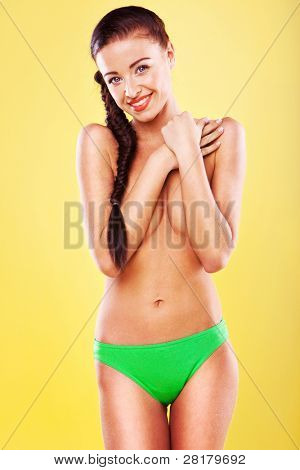 Sexy Brunette Posing Topless, sexy brunette in bikini with her arms across her breasts, implied topless.