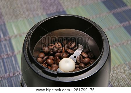 Coffee Beans In A Coffee Grinder. Bamboo Mat. Closeup.