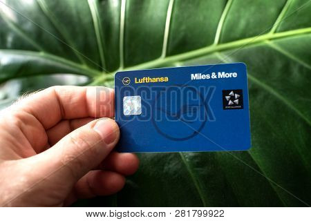 Frankfurt, Germany - Dec 18, 2018: Man Hodling Against Green Leafe Background A New Lufthansa Miles 