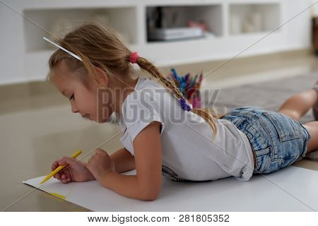 Happy Little Girl Drawing. Cute Kid Lying At Home On The Floor Among Cologed Paper And Pencils. Diy,