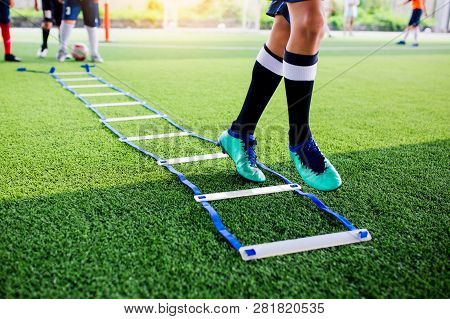 Young Boy Soccer Players Jogging And Jump Between Ladder Drills For Football Training