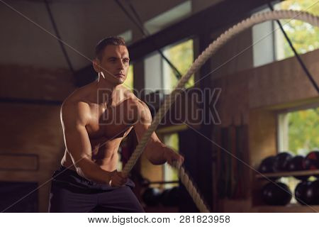 Fit, Sporty And Athletic Sportsman Working In A Gym. Man Training Using Battle Ropes. Sports, Athlet