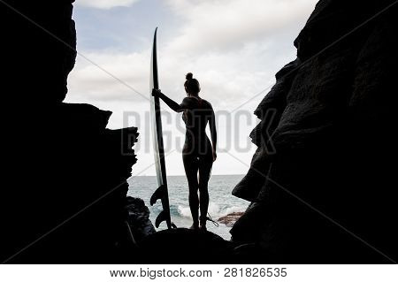 Silhouette Girl In The Swimsuit Standing With The Surf Looking Down