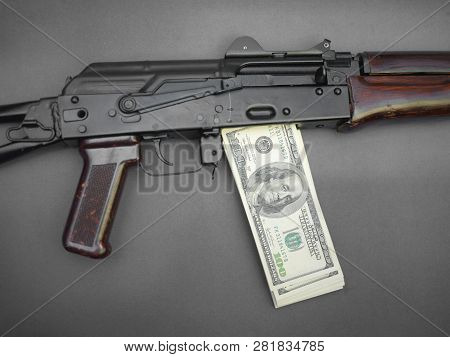 Closeup Of Machine Gun With Dollar Banknotes Instead Of Magazine