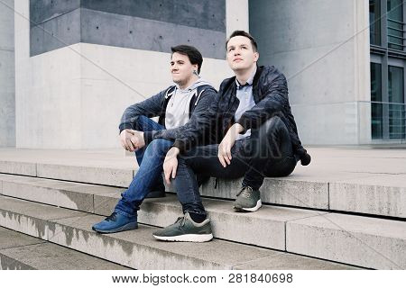Two Male Teenage Friends Or Brothers Two Male Teenage Friends Sitting On Concrete Steps Or Staircase