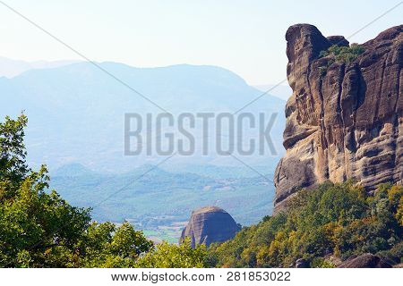 Typical View Of Meteora With High Rocks And Plain Background