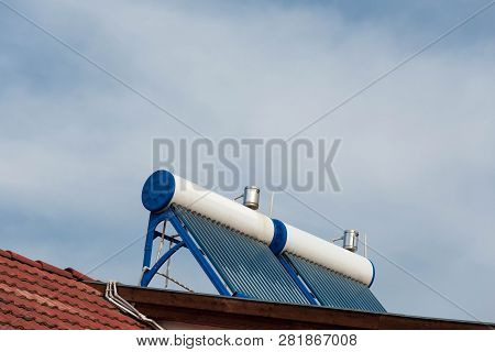 Twin Solar Water Heater Boilers On Residentual House Rooftop On A Cloudy Day.