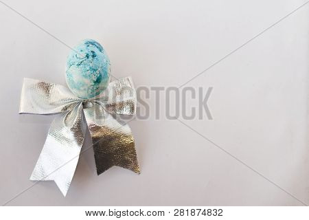 Easter Background With Easter Blue Egg . With Bow. Top View With Copy Space.