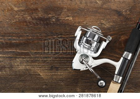 Rubel Reel And Fishing Rod On A Wooden Background. View From Above