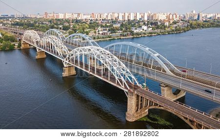 Aerial Top View Of Automobile And Railroad Darnitsky Bridge Across Dnieper River From Above, Kiev (k