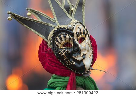 Traditional Venetian Carnival Joker Mask, Black And White Faced, With Peaks And Bells, Above Green A