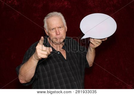 Man with Word Balloon. A middle aged man holds a Word Balloon or Thought Bubble while in a Photo Booth. Room for your text. Red Burgundy Velvet Background. 