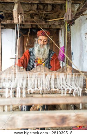 Kullu, Himachal Pradesh, India - August 09, 2018 : An Indian Old Man Makes A Traditional Sadu Weavin