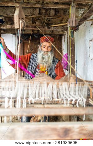 Kullu, Himachal Pradesh, India - August 09, 2018 : An Indian Old Man Makes A Traditional Sadu Weavin