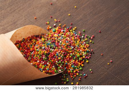 Colorful Sprinkles In Craf Paper Cornet On Dark Background