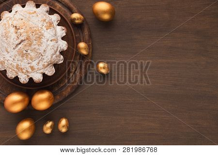 Easter Cake With Powdered Sugar And Golden Eggs On Wooden Table, Copy Space