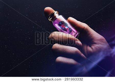 Human Hand Holding Glass Bottle With Cell Dividing. Mixed Media.