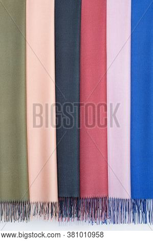 Several Luxurious Women's Cashmere Shawls, Scarves In Multi-colored Tones On A Metal Hanger. Studio 