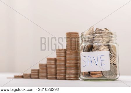Saving Money, Coin In Glass Bottle With Money Stack. Financial Business Investment Concept.