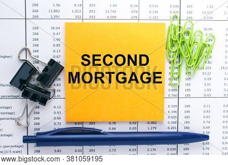 Text Second Mortgage On Financial Tables With Pen, Glasses And Paper Clips