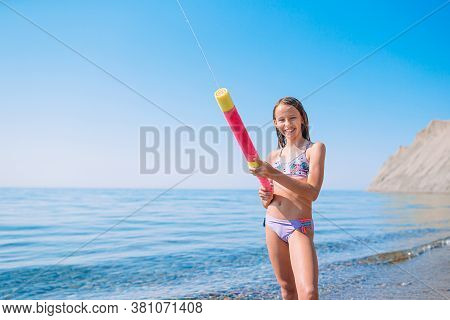 Adorable Active Little Girl At Beach During Summer Vacation