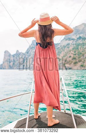 Woman In Hat And Dress Sailing On Boat In Clear Open Sea