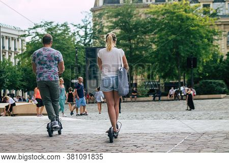 Reims France August 15, 2020 View Of Unidentified People Rolling With An Electric Scooter In The Str