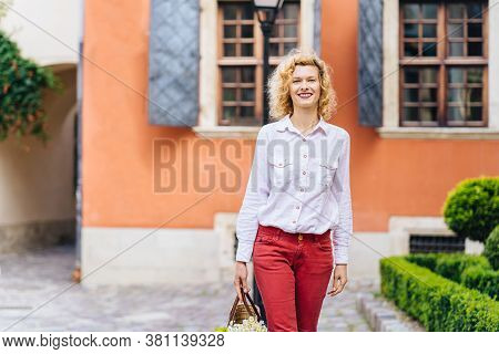 Portrait Of Romantic Mature Slim Blonde Woman In White Shirt Red Pants Enjoying, Walking Outdoor In 