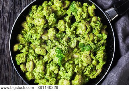 Italian Gnocchi With Broccoli Florets Tossed With Basil Pesto And Creamy Cheese Sauce In A Skillet. 
